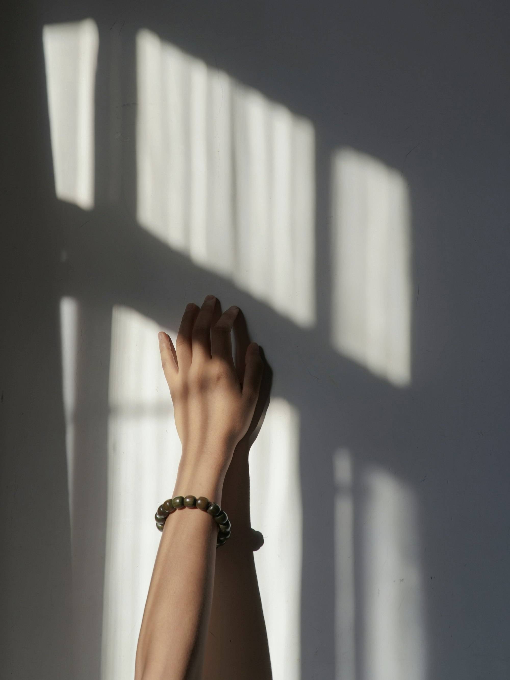 Una mano en la luz cálida de una ventana